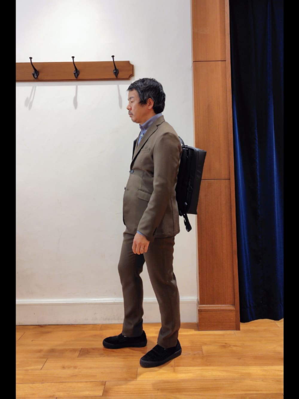 ブラック系のバックパック/リュック、グリーン系のテーラードジャケット、グリーン系のその他パンツを着用したメンズの春コーディネートの4枚目の写真