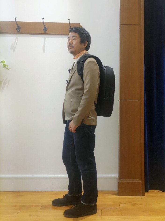 ベージュ系のテーラードジャケット、ブラック系のバックパック/リュックを着用したメンズの春コーディネートの4枚目の写真