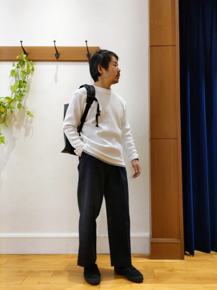 ホワイト系のTシャツ/カットソー、ブラック系のバックパック/リュック、ブルー系のデニムパンツを着用したメンズの冬コーディネートの2枚目の写真
