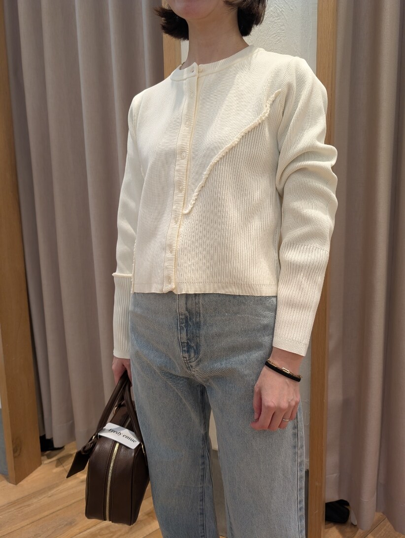 ホワイト系のカーディガン/ボレロ、ブルー系のデニムパンツ、ブラウン系のハンドバッグを着用したレディースの冬コーディネートの5枚目の写真