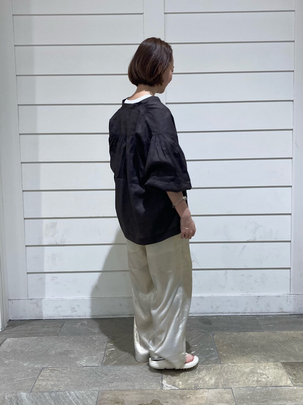 ブラウン系のシャツ/ブラウス、ゴールド系のその他パンツ、ホワイト系のTシャツ/カットソーを着用したレディースの夏コーディネートの3枚目の写真