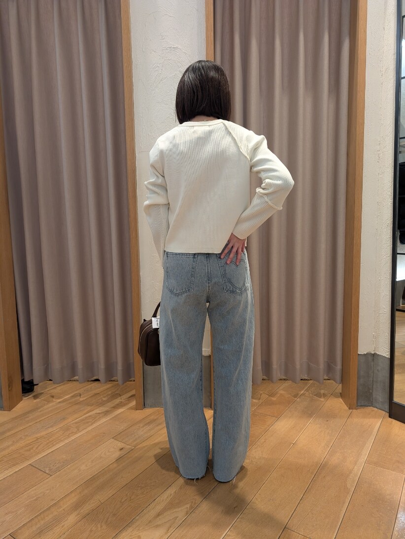 ホワイト系のカーディガン/ボレロ、ブルー系のデニムパンツ、ブラウン系のハンドバッグを着用したレディースの冬コーディネートの3枚目の写真