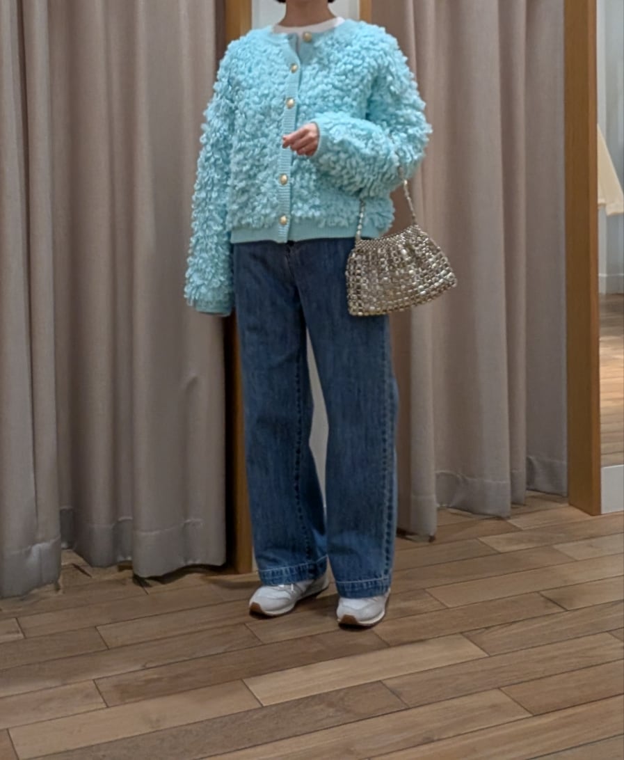 シルバー系のハンドバッグ、グリーン系のカーディガン/ボレロ、ブルー系のデニムパンツを着用したレディースの冬コーディネートの5枚目の写真