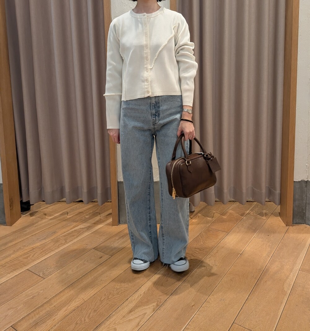 ホワイト系のカーディガン/ボレロ、ブルー系のデニムパンツ、ブラウン系のハンドバッグを着用したレディースの冬コーディネートの6枚目の写真