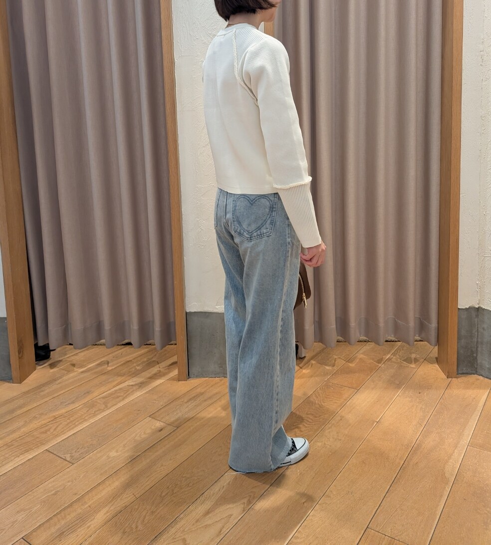 ホワイト系のカーディガン/ボレロ、ブルー系のデニムパンツ、ブラウン系のハンドバッグを着用したレディースの冬コーディネートの2枚目の写真