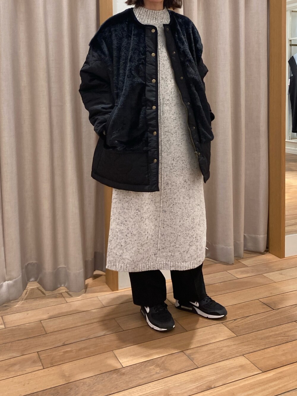 ブラック系のブルゾン、グレー系のワンピースを着用したレディースの冬コーディネートの2枚目の写真