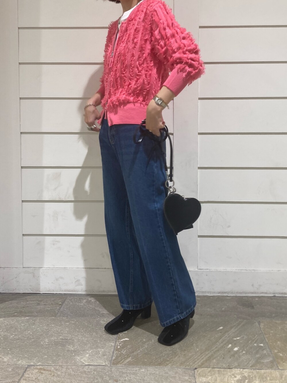 ピンク系のカーディガン/ボレロ、ブルー系のデニムパンツ、ブラック系のショルダーバッグを着用したレディースの秋コーディネートの2枚目の写真