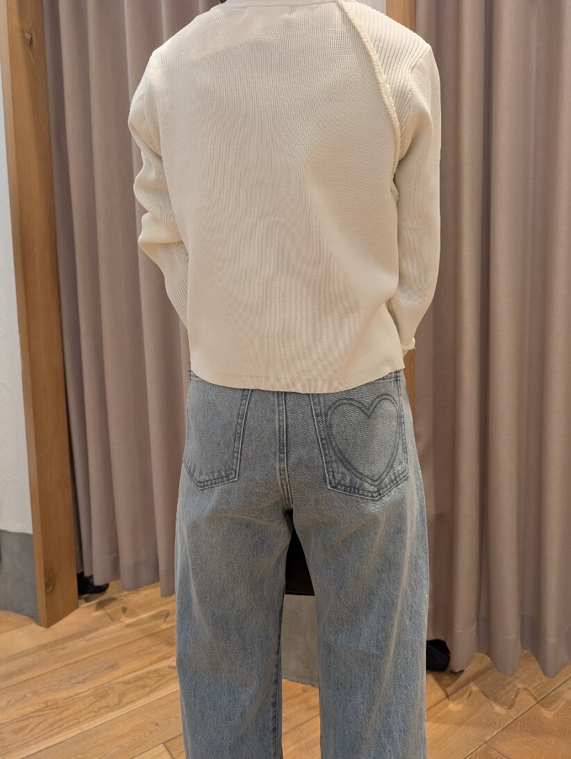 ホワイト系のカーディガン/ボレロ、ブルー系のデニムパンツ、ブラウン系のハンドバッグを着用したレディースの冬コーディネートの4枚目の写真