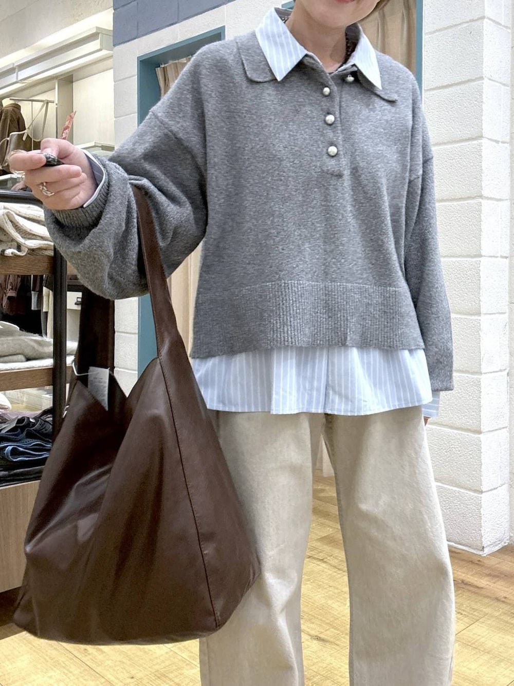 ベージュ系のデニムパンツ、ブラウン系のショルダーバッグ、ブラック系のローファーを着用したレディースの冬コーディネートの6枚目の写真