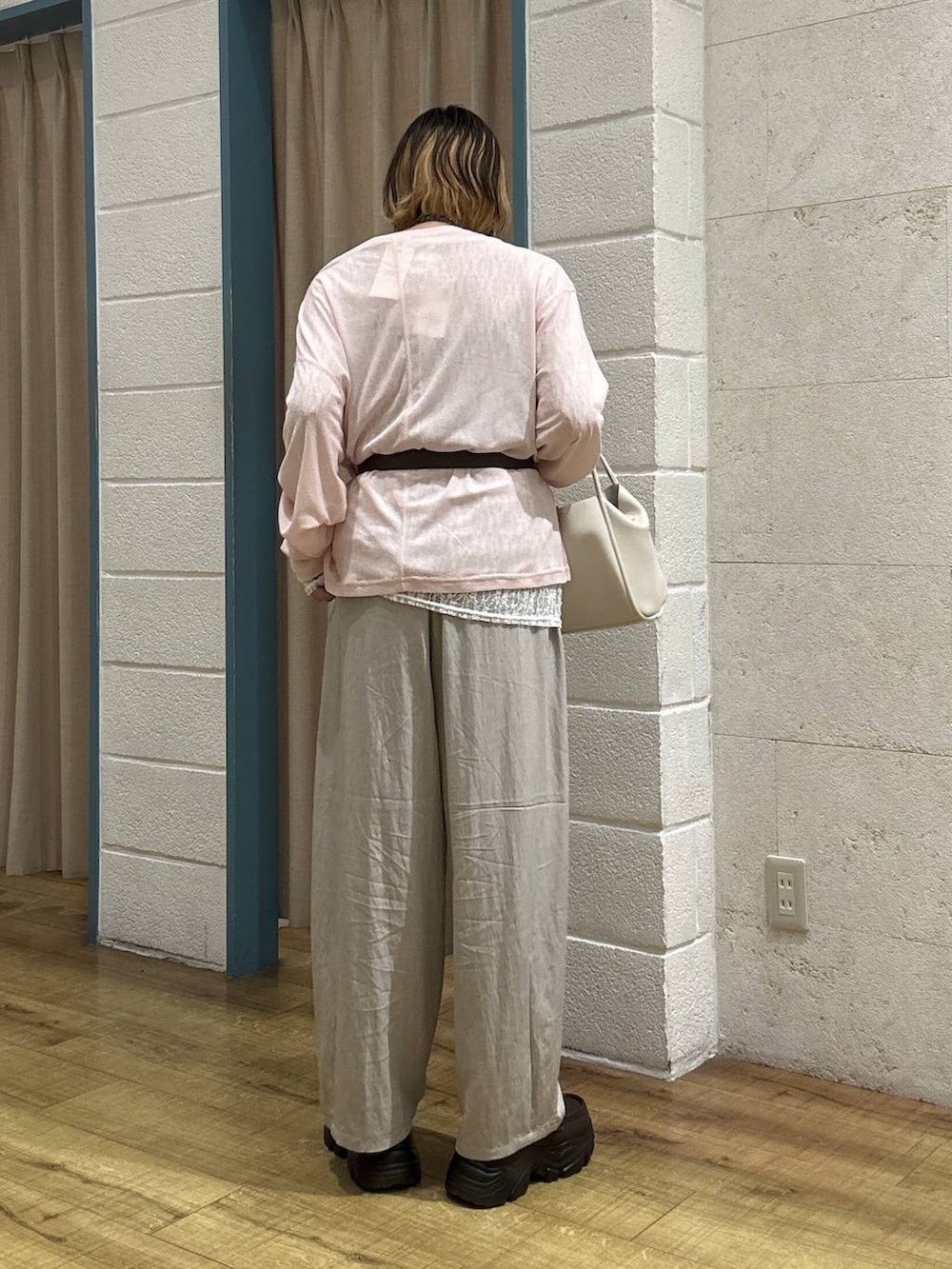 ホワイト系のショルダーバッグ、ピンク系のTシャツ/カットソー、ブラウン系のローファーを着用したレディースの春コーディネートの4枚目の写真