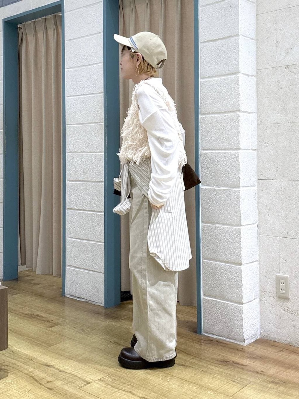 ホワイト系のTシャツ/カットソー、ベージュ系のデニムパンツ、ブラウン系のサンダルを着用したレディースの春コーディネートの3枚目の写真