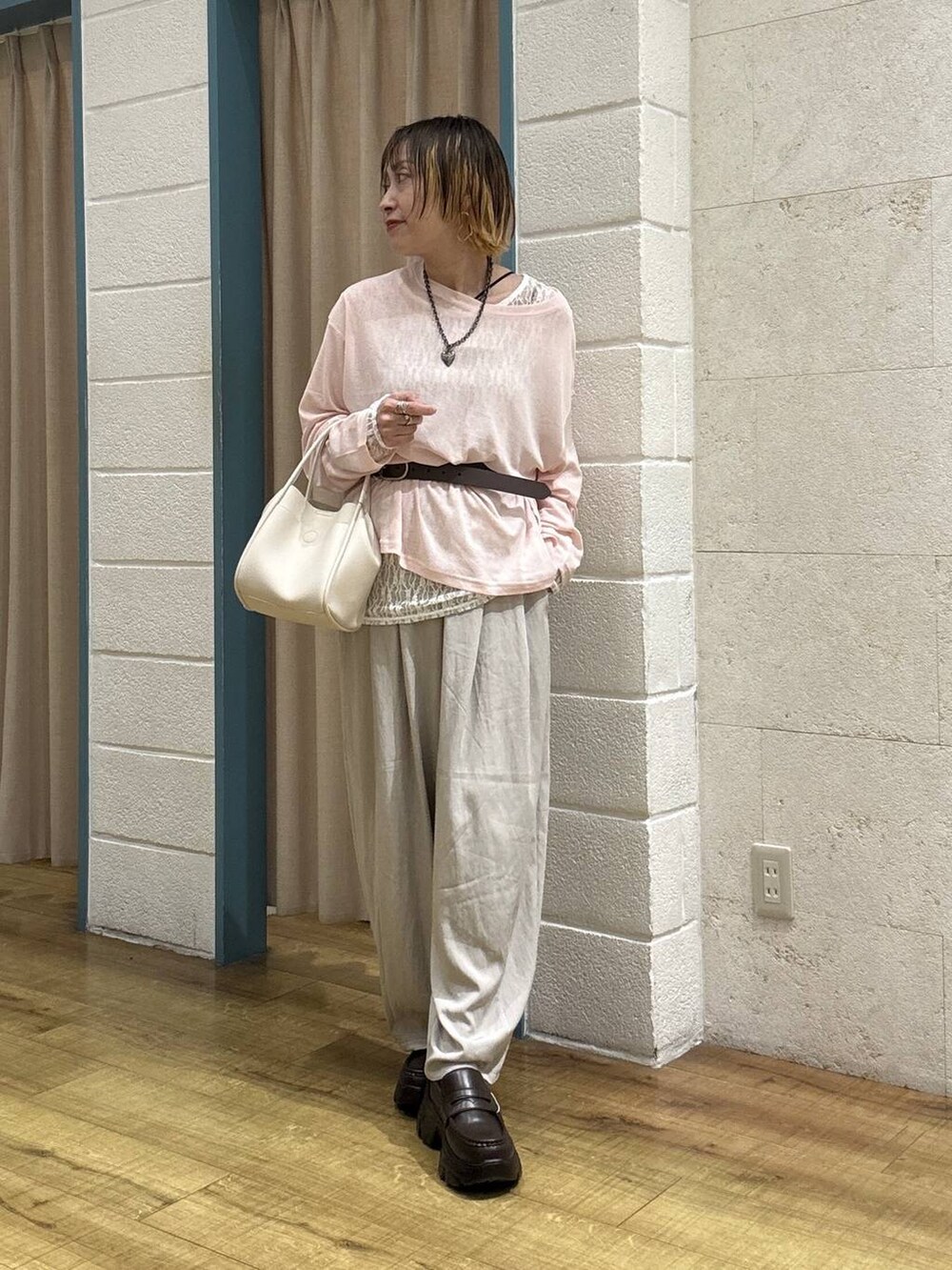 ホワイト系のショルダーバッグ、ピンク系のTシャツ/カットソー、ブラウン系のローファーを着用したレディースの春コーディネートの6枚目の写真