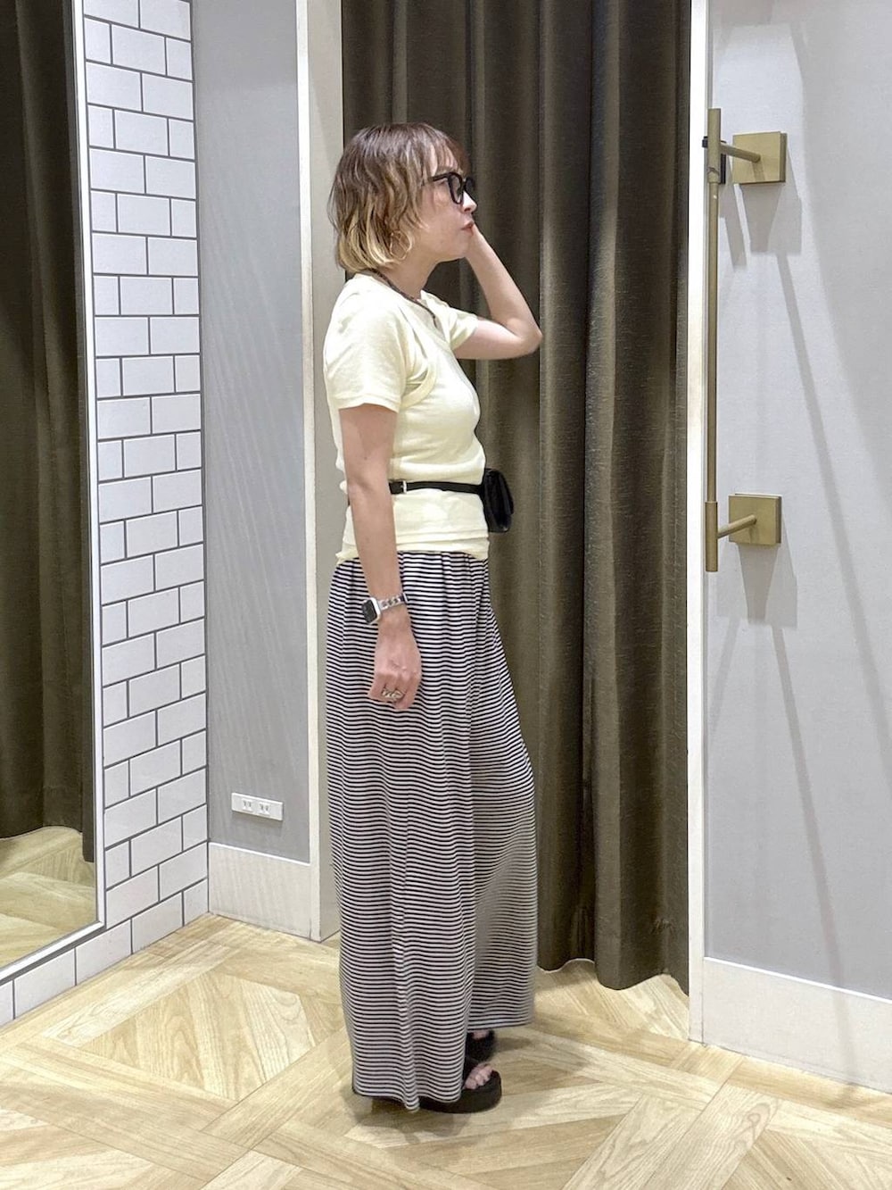 イエロー系のTシャツ/カットソー、ホワイト系のその他パンツ、ブラック系のサンダルを着用したレディースの夏コーディネートの5枚目の写真