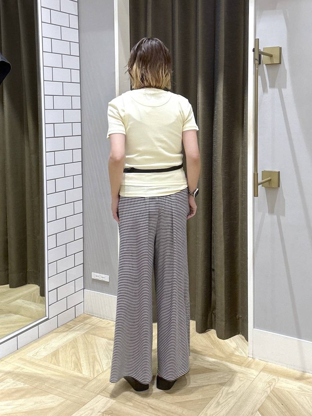 イエロー系のTシャツ/カットソー、ホワイト系のその他パンツ、ブラック系のサンダルを着用したレディースの夏コーディネートの4枚目の写真