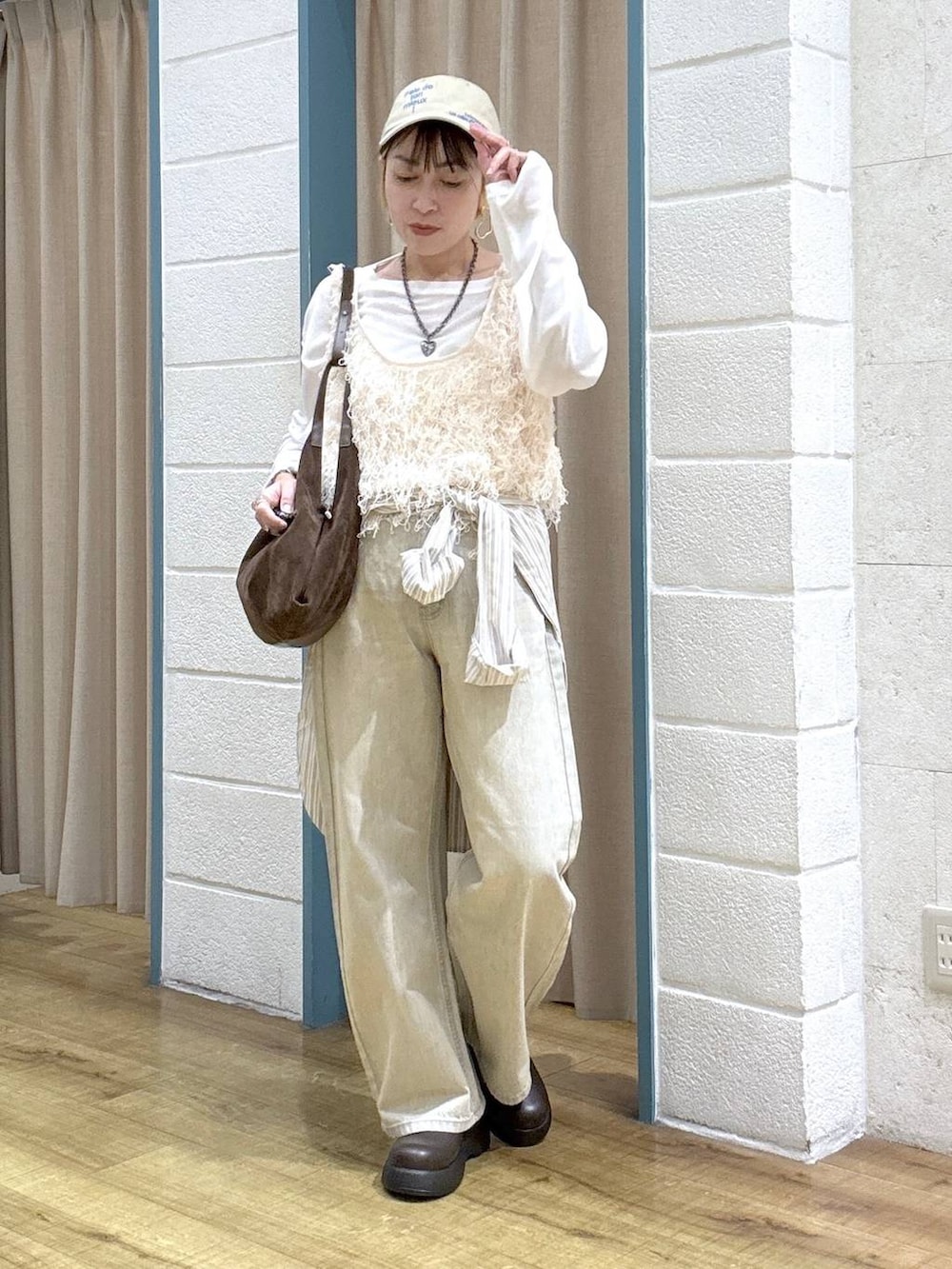 ホワイト系のTシャツ/カットソー、ベージュ系のデニムパンツ、ブラウン系のサンダルを着用したレディースの春コーディネートの2枚目の写真