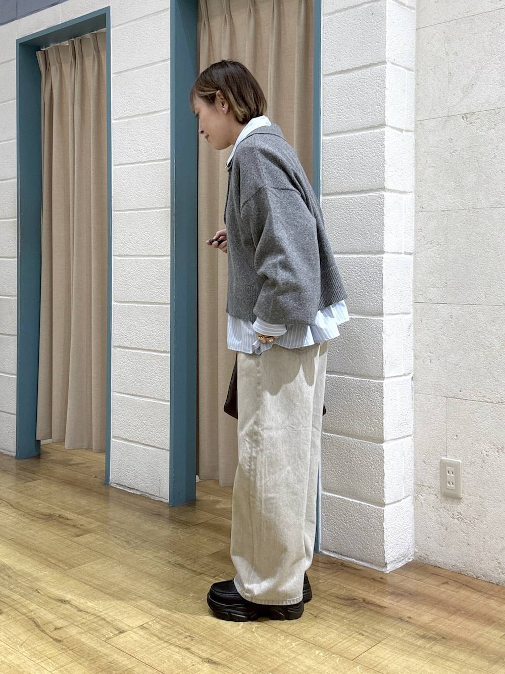 ベージュ系のデニムパンツ、ブラウン系のショルダーバッグ、ブラック系のローファーを着用したレディースの冬コーディネートの2枚目の写真