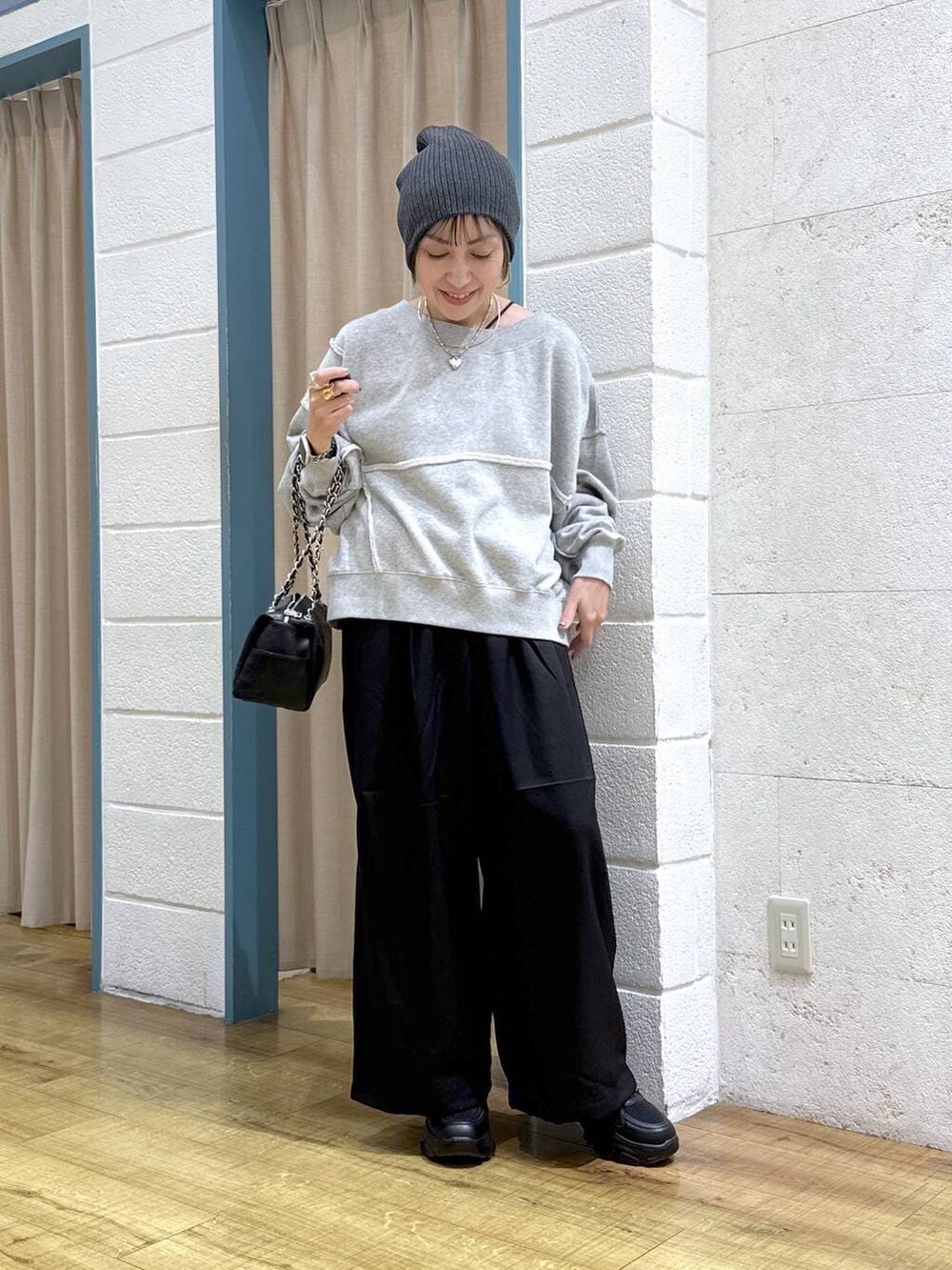 ブラック系のブーツ、グレー系のスウェット、ブラック系のショルダーバッグを着用したレディースの冬コーディネートの2枚目の写真