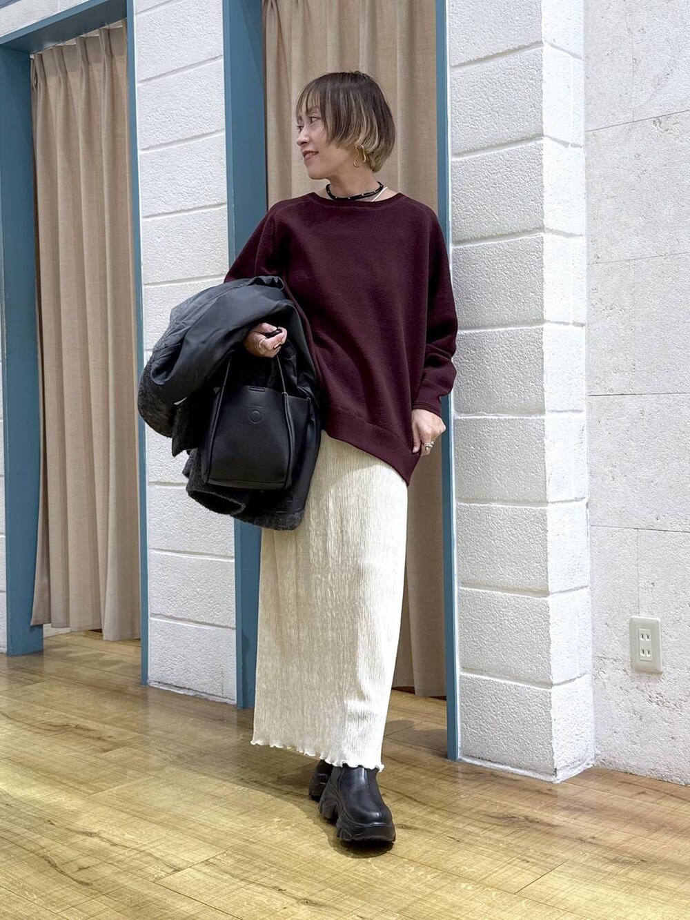 ブラック系のブーツ、グレー系のその他アウター、ブラック系のショルダーバッグを着用したレディースの秋コーディネートの7枚目の写真