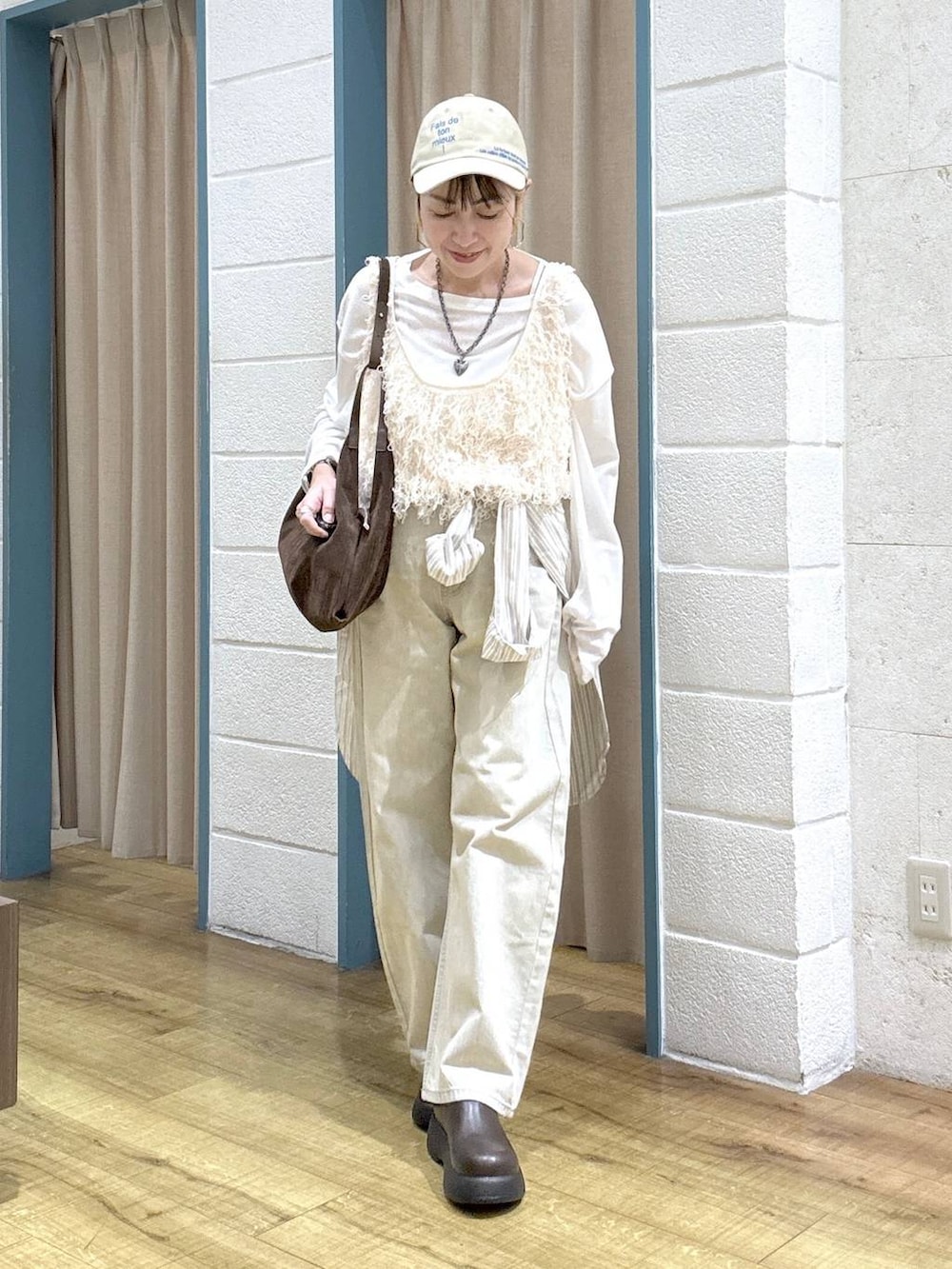 ホワイト系のTシャツ/カットソー、ベージュ系のデニムパンツ、ブラウン系のサンダルを着用したレディースの春コーディネートの6枚目の写真