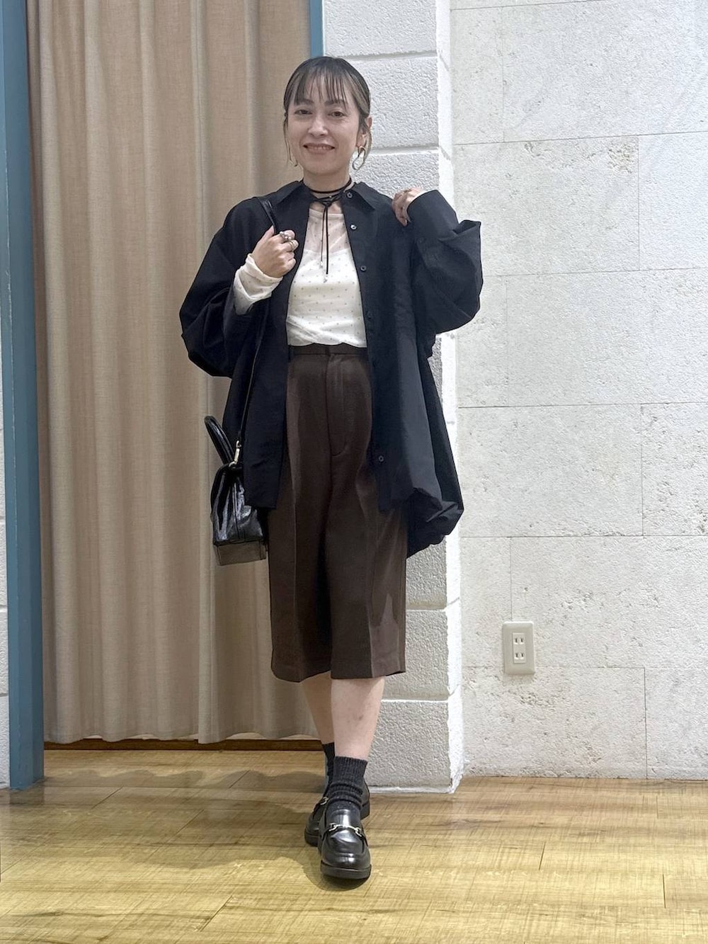 ブラウン系のその他パンツ、ブラック系のボストンバッグ、ブラック系のシャツ/ブラウスを着用したレディースの秋コーディネートの6枚目の写真
