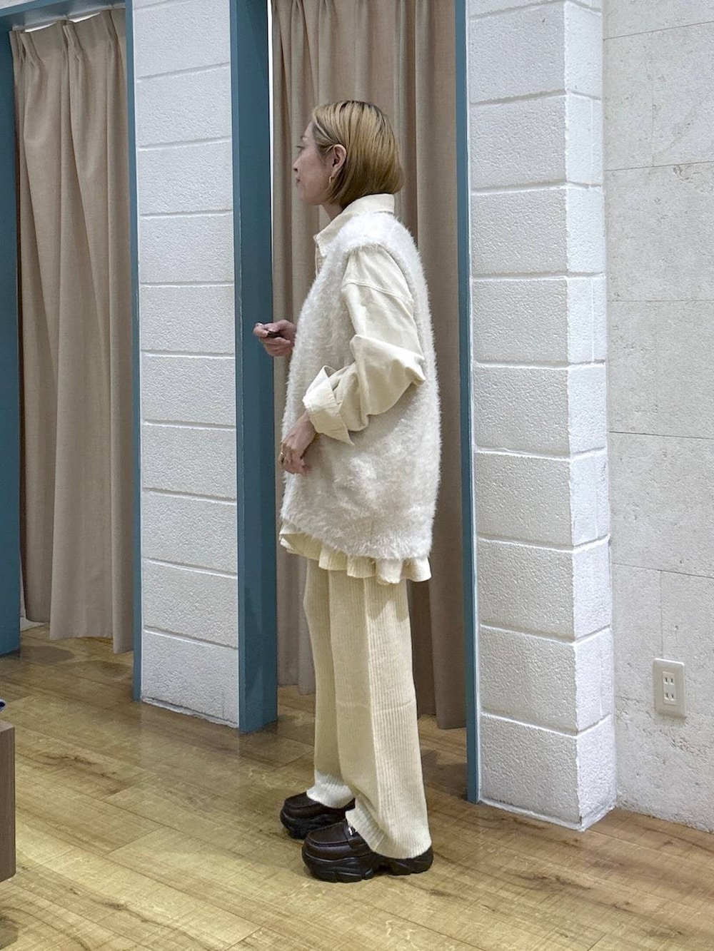 ブラウン系のボストンバッグ、イエロー系のその他パンツ、ホワイト系のベストを着用したレディースの秋コーディネートの3枚目の写真