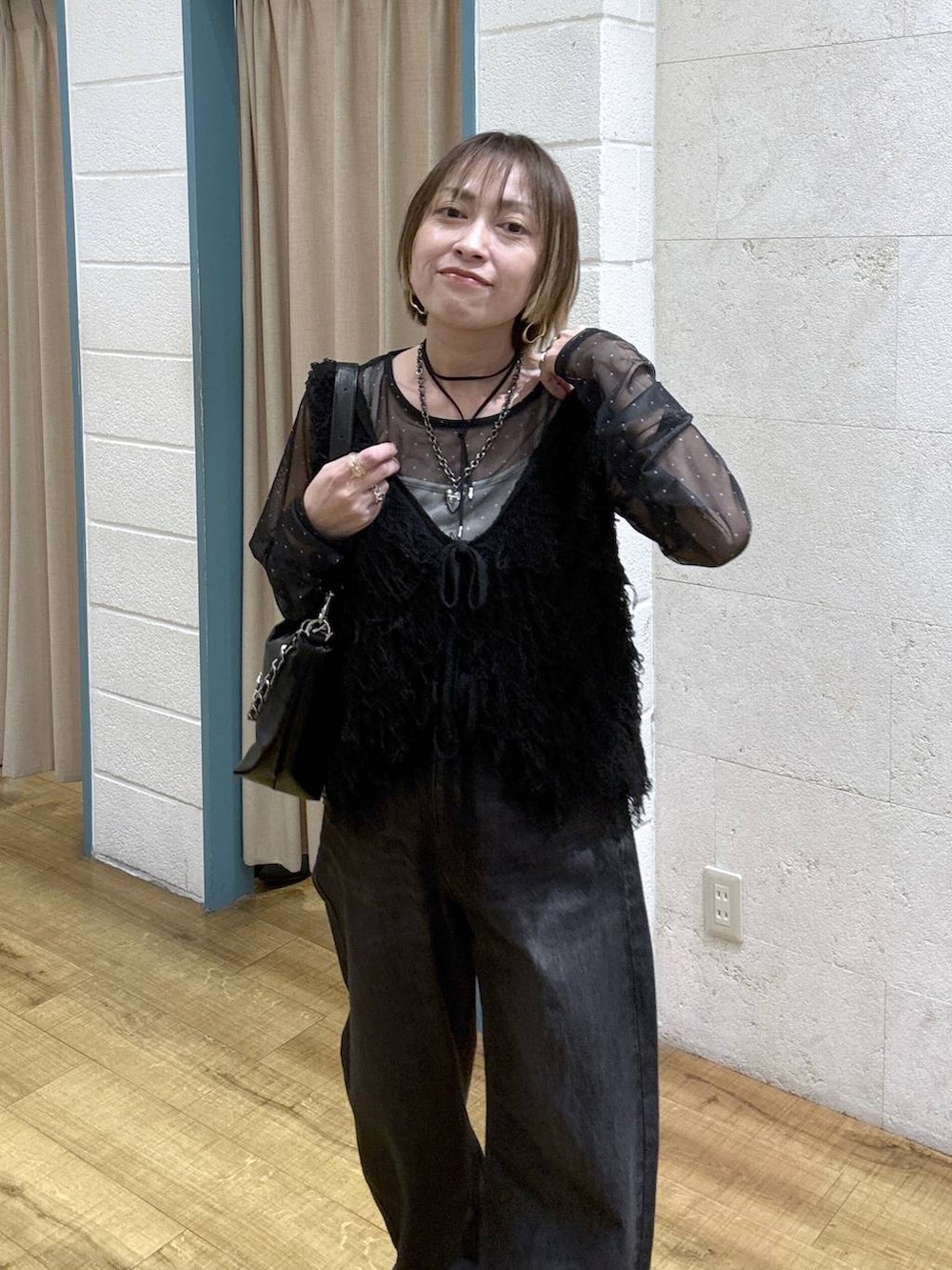 ブラック系のTシャツ/カットソー、ブラック系のデニムパンツ、シルバー系のスニーカーを着用したレディースの冬コーディネートの7枚目の写真