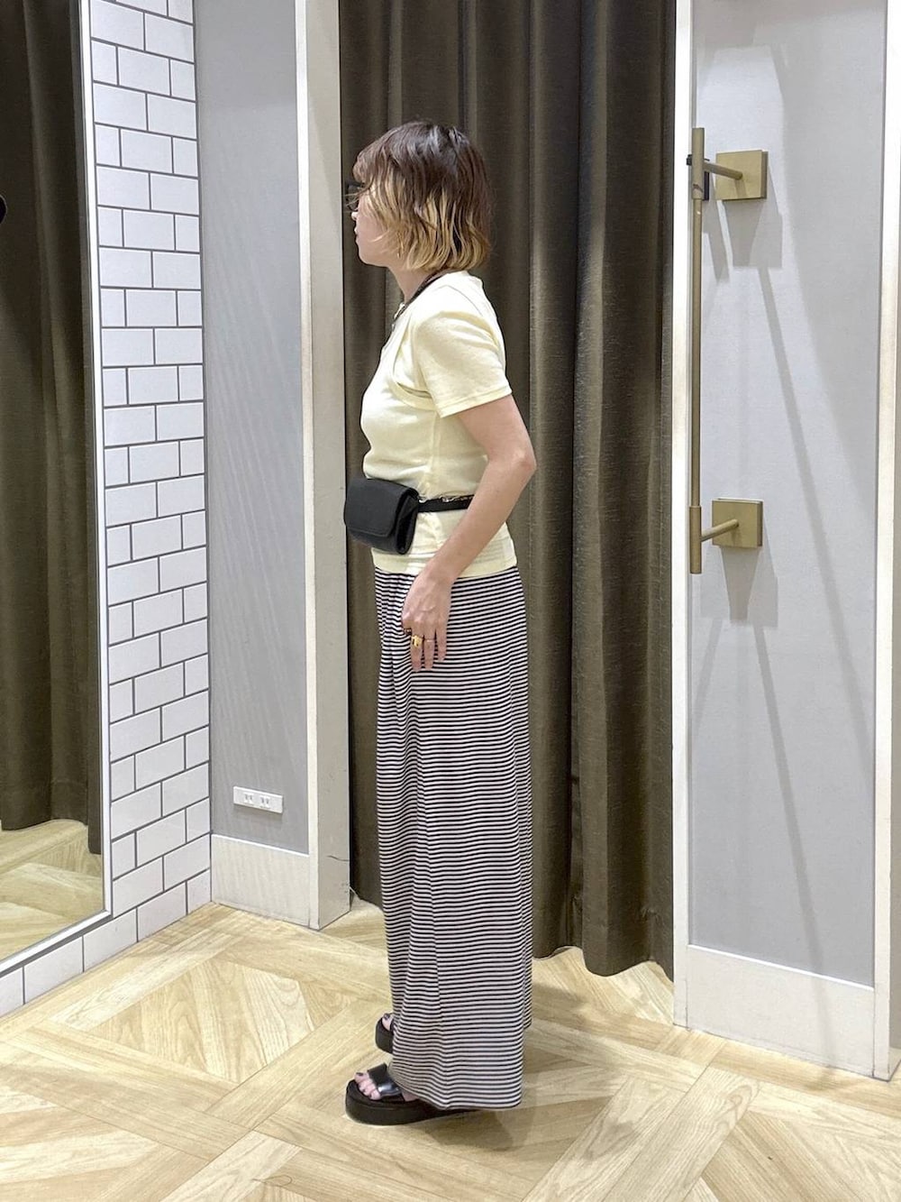 イエロー系のTシャツ/カットソー、ホワイト系のその他パンツ、ブラック系のサンダルを着用したレディースの夏コーディネートの3枚目の写真