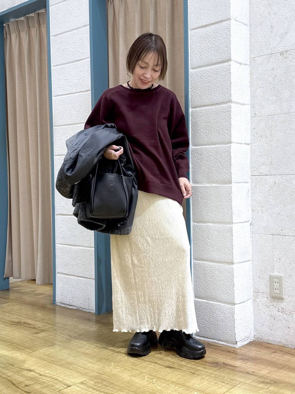 ブラック系のブーツ、グレー系のその他アウター、ブラック系のショルダーバッグを着用したレディースの秋コーディネートの6枚目の写真