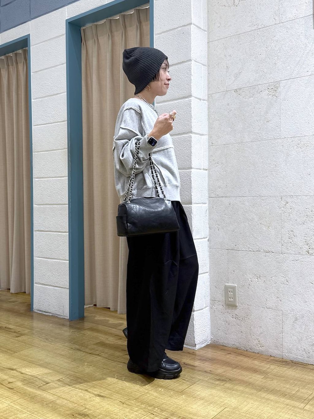 ブラック系のブーツ、グレー系のスウェット、ブラック系のショルダーバッグを着用したレディースの冬コーディネートの3枚目の写真