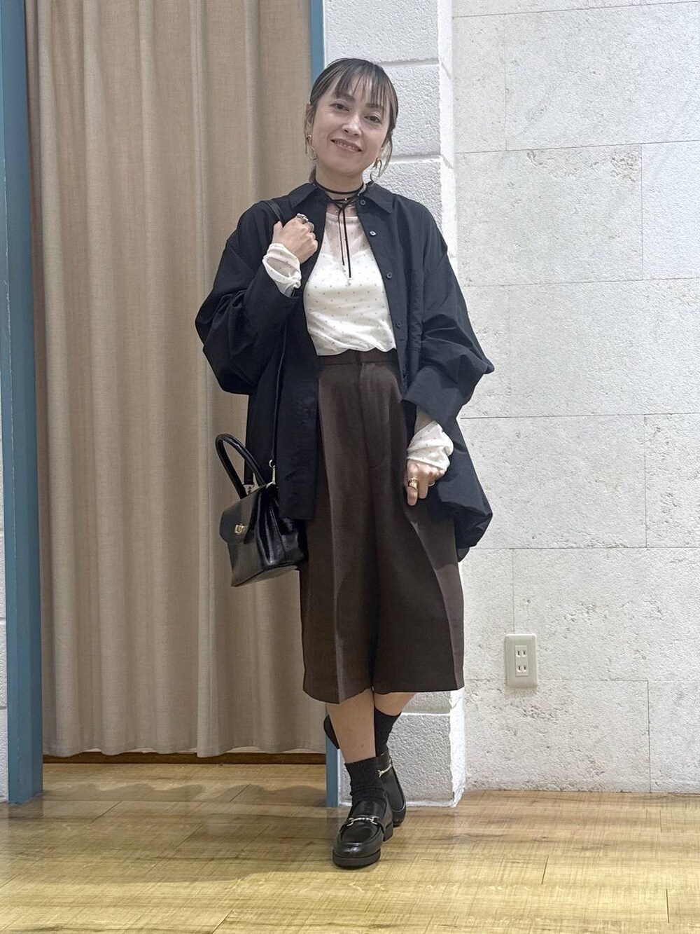 ブラウン系のその他パンツ、ブラック系のボストンバッグ、ブラック系のシャツ/ブラウスを着用したレディースの秋コーディネートの7枚目の写真