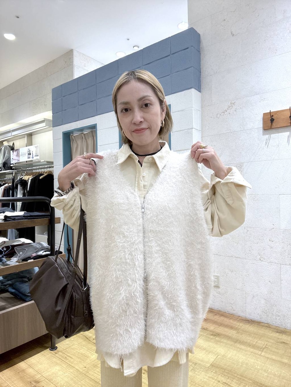 ブラウン系のボストンバッグ、イエロー系のその他パンツ、ホワイト系のベストを着用したレディースの秋コーディネートの5枚目の写真