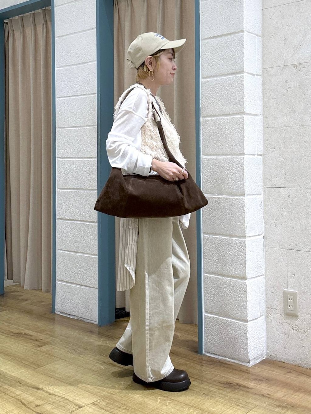 ホワイト系のTシャツ/カットソー、ベージュ系のデニムパンツ、ブラウン系のサンダルを着用したレディースの春コーディネートの5枚目の写真