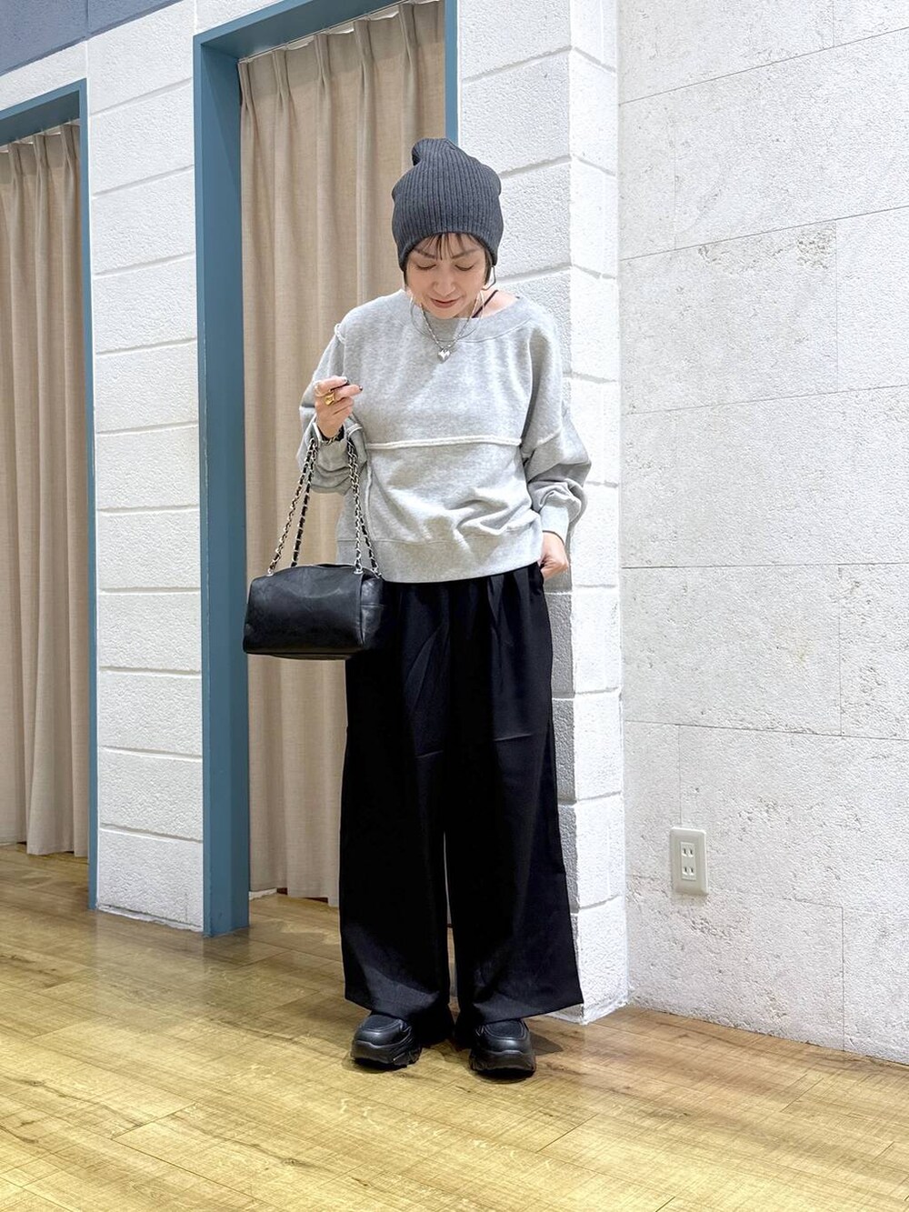 ブラック系のブーツ、グレー系のスウェット、ブラック系のショルダーバッグを着用したレディースの冬コーディネートの6枚目の写真