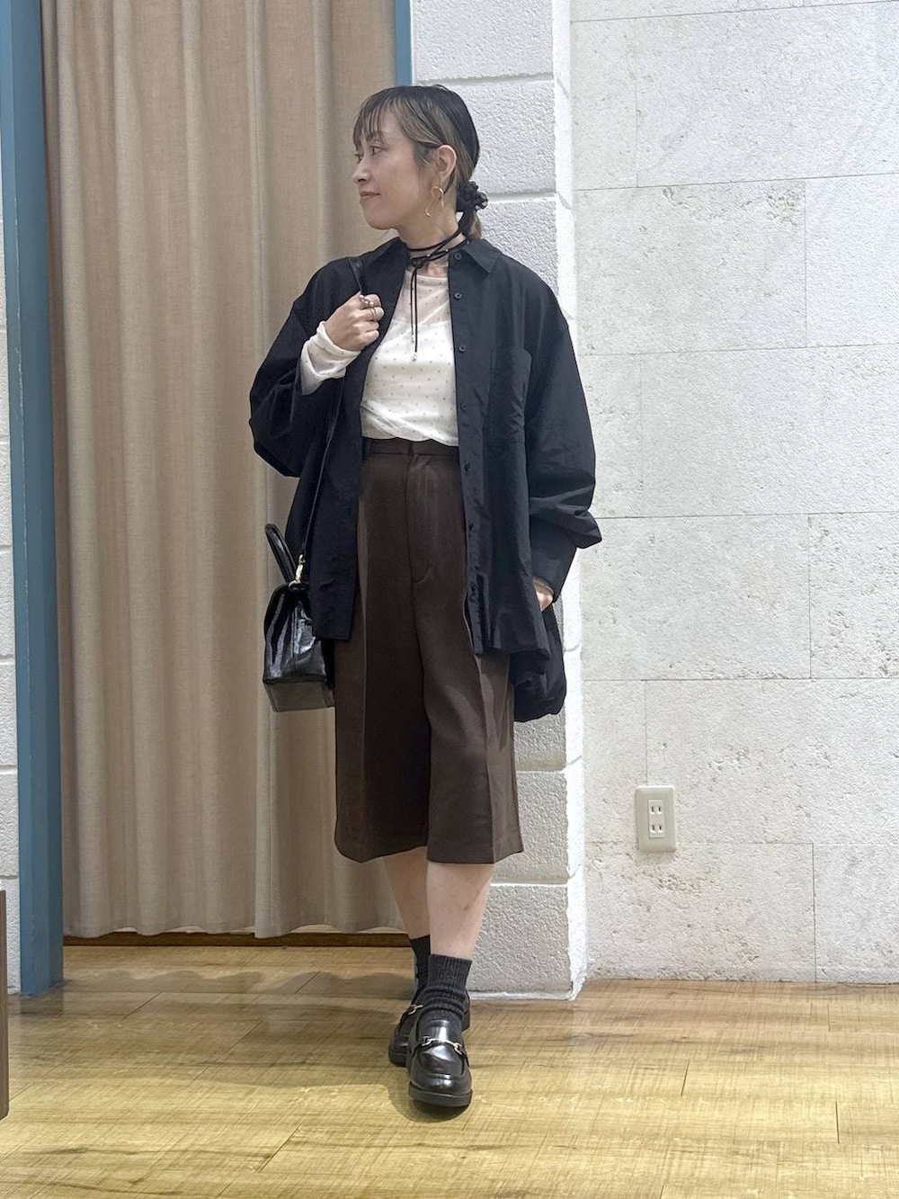 ブラウン系のその他パンツ、ブラック系のボストンバッグ、ブラック系のシャツ/ブラウスを着用したレディースの秋コーディネートの8枚目の写真