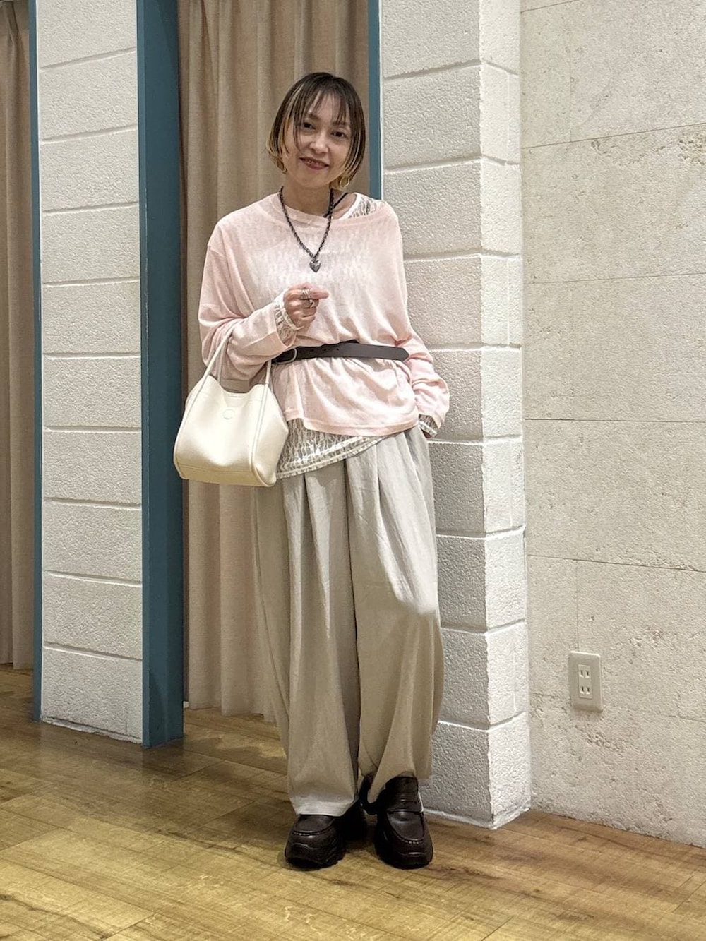 ホワイト系のショルダーバッグ、ピンク系のTシャツ/カットソー、ブラウン系のローファーを着用したレディースの春コーディネートの2枚目の写真