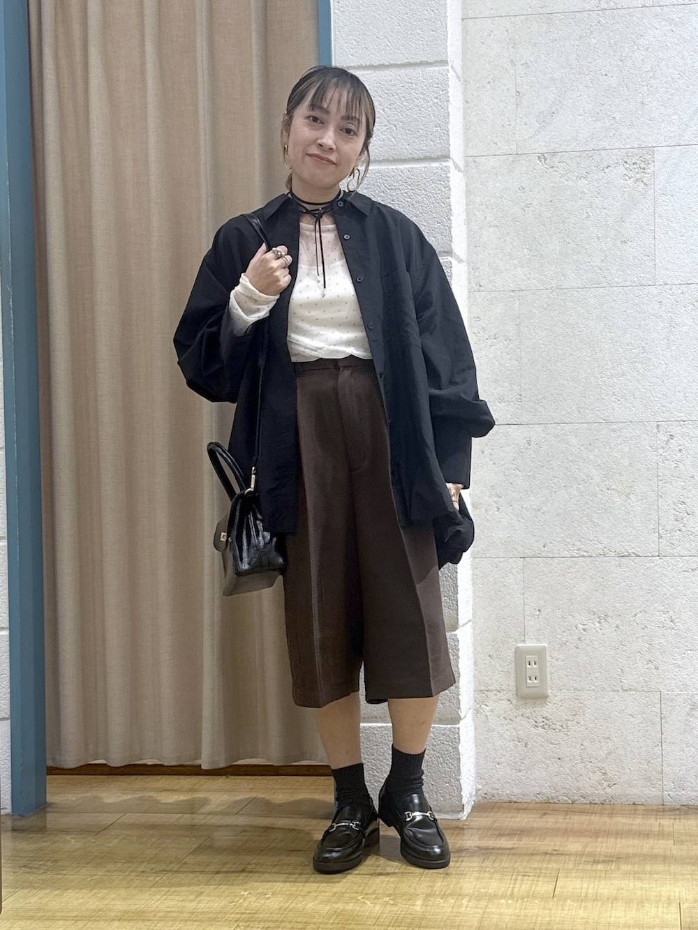 ブラウン系のその他パンツ、ブラック系のボストンバッグ、ブラック系のシャツ/ブラウスを着用したレディースの秋コーディネートの2枚目の写真