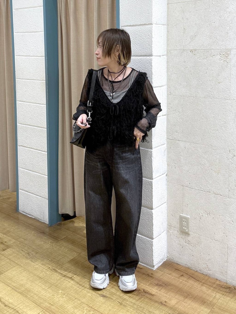 ブラック系のTシャツ/カットソー、ブラック系のデニムパンツ、シルバー系のスニーカーを着用したレディースの冬コーディネートの2枚目の写真