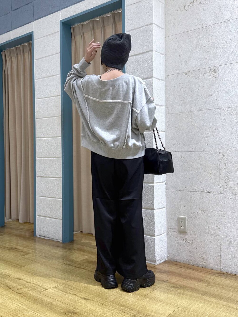 ブラック系のブーツ、グレー系のスウェット、ブラック系のショルダーバッグを着用したレディースの冬コーディネートの4枚目の写真