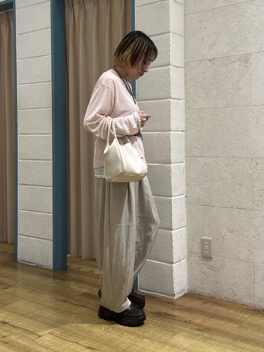 ホワイト系のショルダーバッグ、ピンク系のTシャツ/カットソー、ブラウン系のローファーを着用したレディースの春コーディネートの5枚目の写真