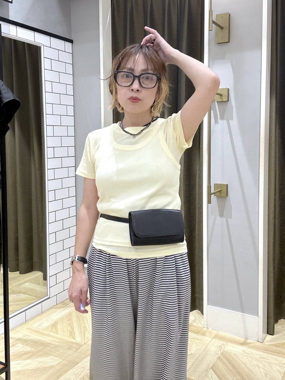 イエロー系のTシャツ/カットソー、ホワイト系のその他パンツ、ブラック系のサンダルを着用したレディースの夏コーディネートの6枚目の写真