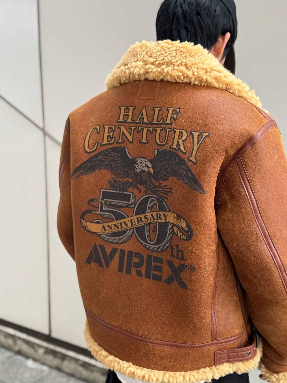 ブラウン系のムートンコート、ブラック系のカーゴパンツ、ホワイト系のシャツ/ブラウスを着用したメンズの冬コーディネートの2枚目の写真