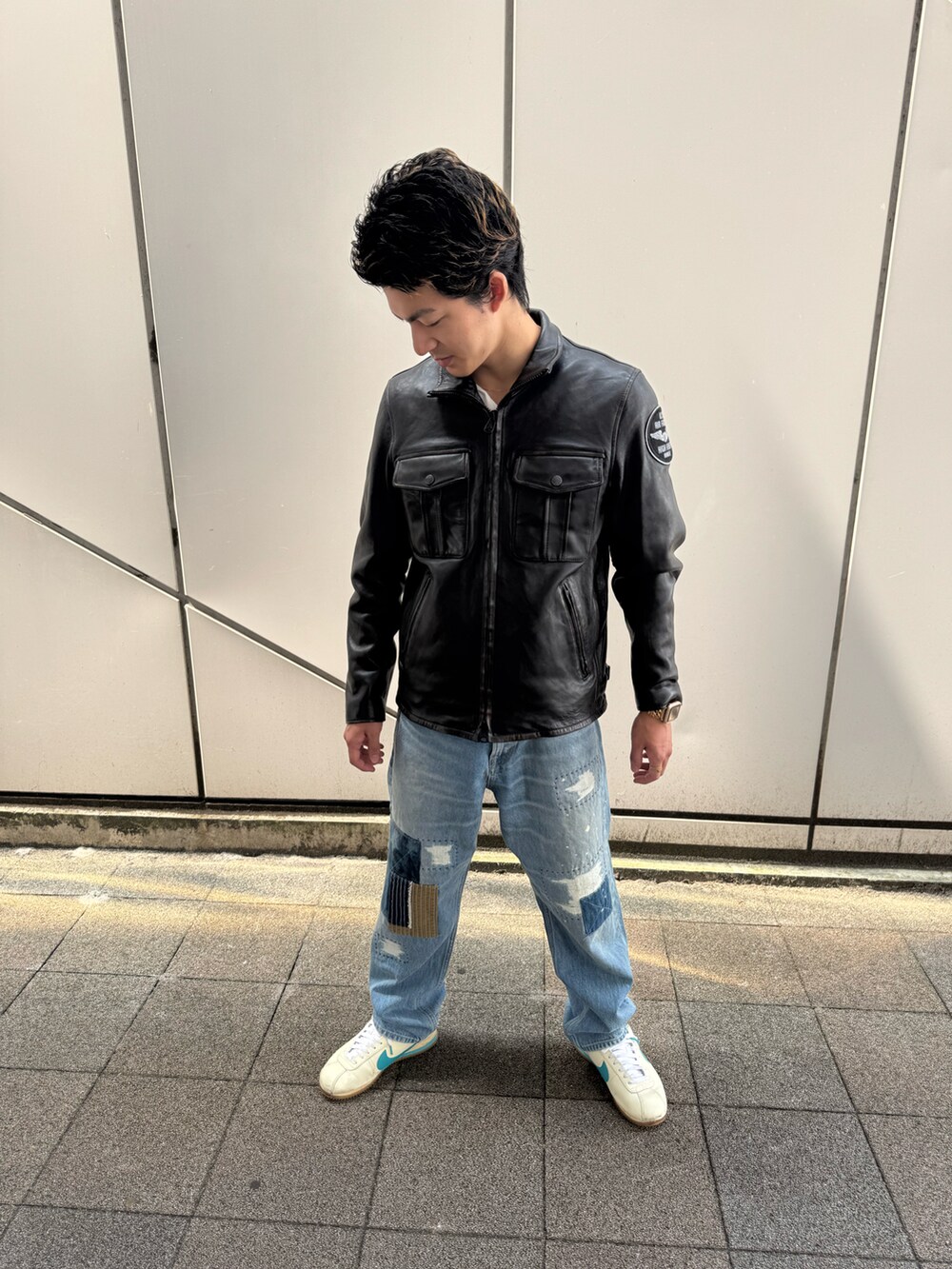ブラック系のライダースジャケット、ブルー系のデニムパンツ、ブラック系のベルトを着用したメンズの夏コーディネートの2枚目の写真