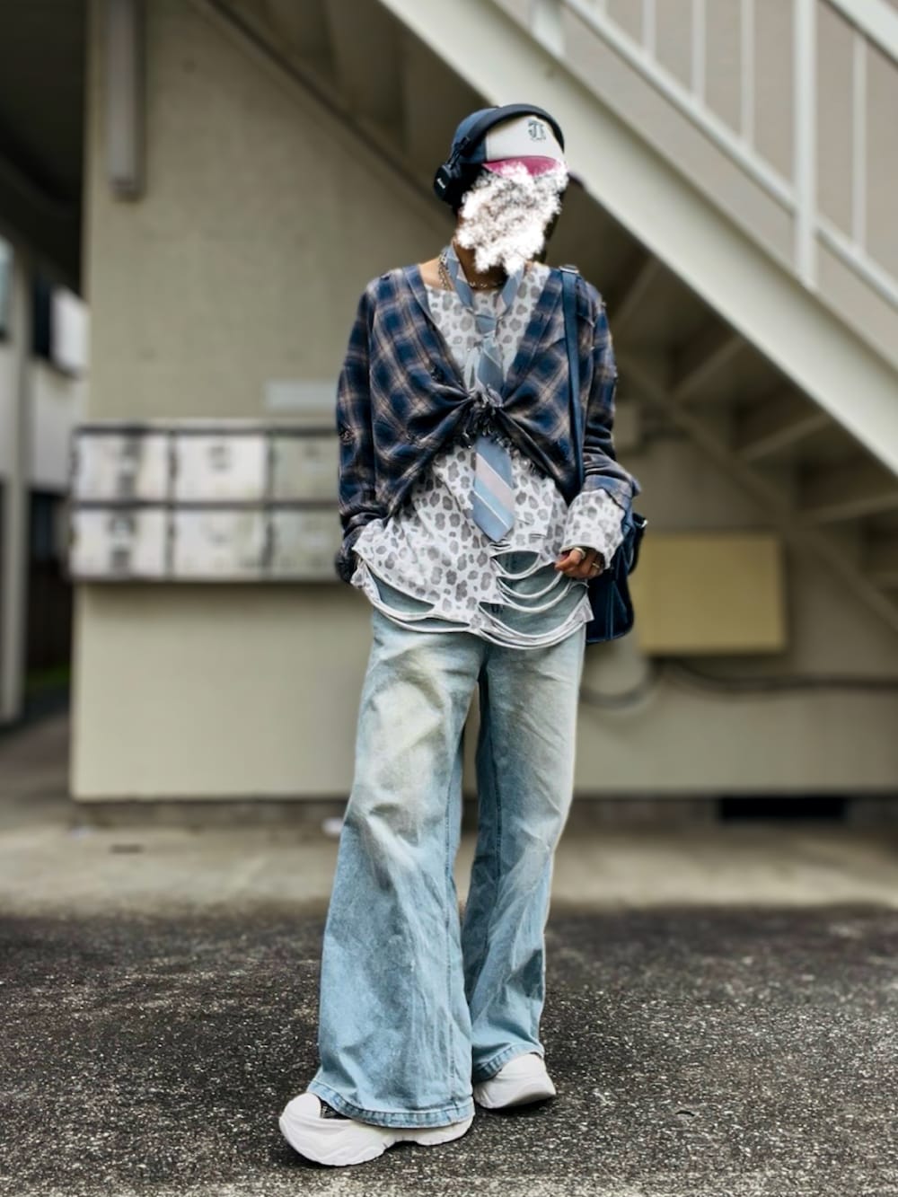 ブラック系のスニーカー、ホワイト系のTシャツ/カットソー、ブルー系のデニムパンツを着用したメンズの秋コーディネートの2枚目の写真