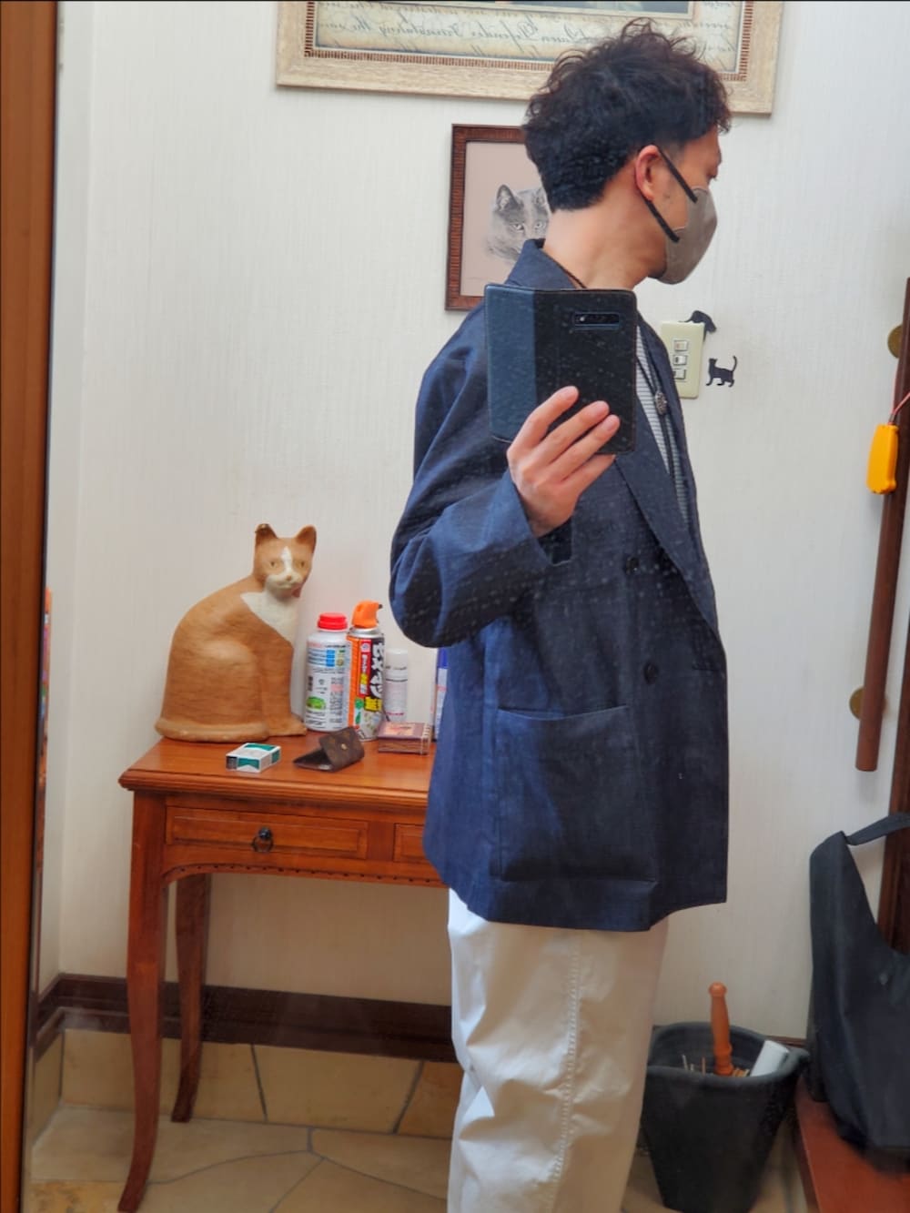 ベージュ系のチノパンツ、グレー系のスニーカー、ブルー系のデニムジャケットを着用したメンズの秋コーディネートの2枚目の写真