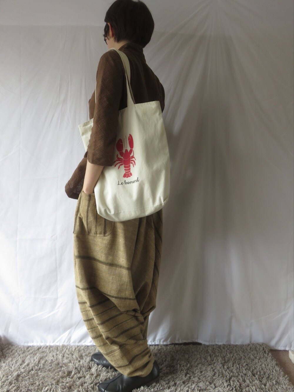 ブラウン系のシャツ/ブラウス、ベージュ系のパンツを着用したレディースの春コーディネートの2枚目の写真