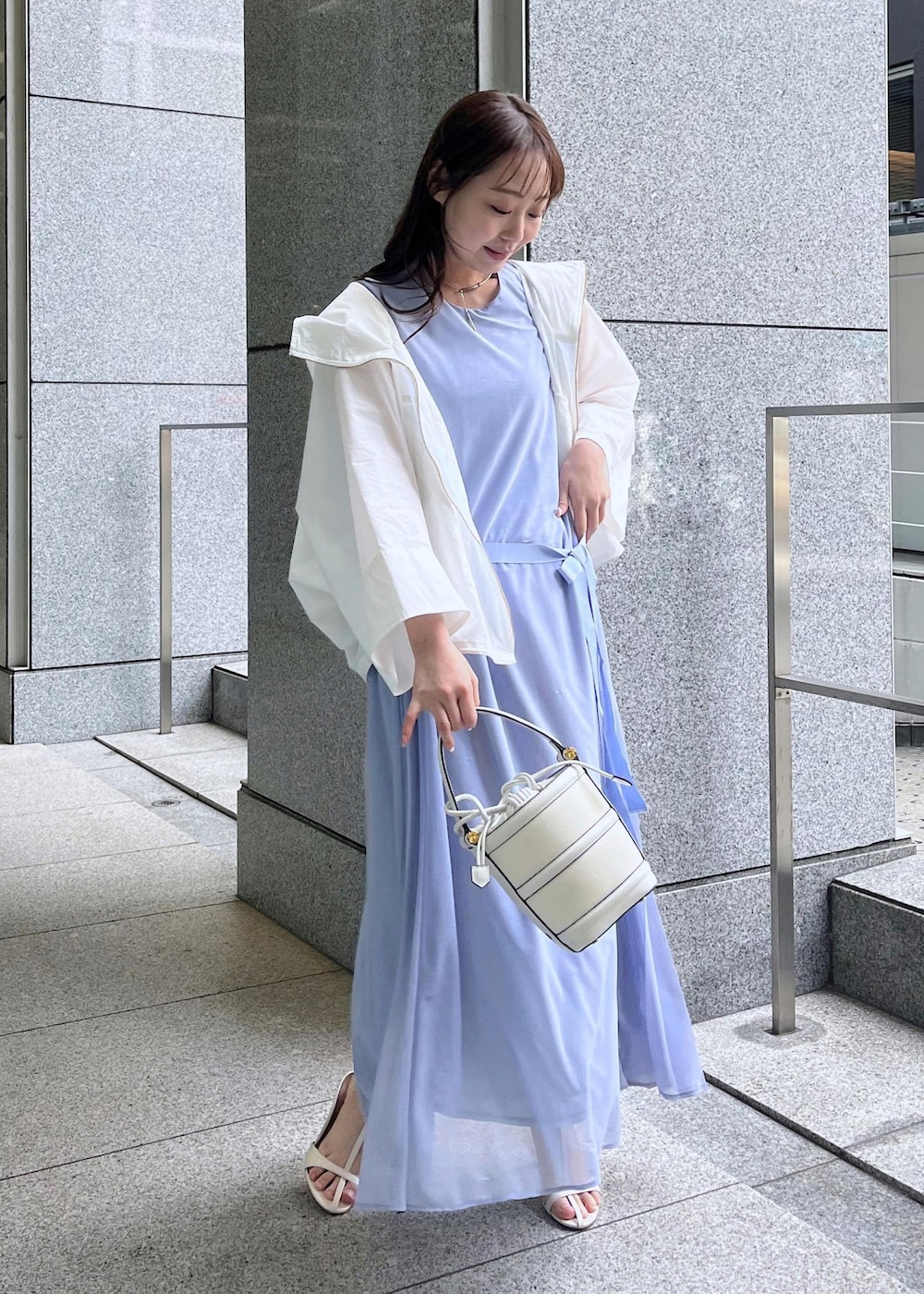 ホワイト系のハンドバッグ、ホワイト系のサンダル、ホワイト系のマウンテンパーカーを着用したレディースの春コーディネートの5枚目の写真