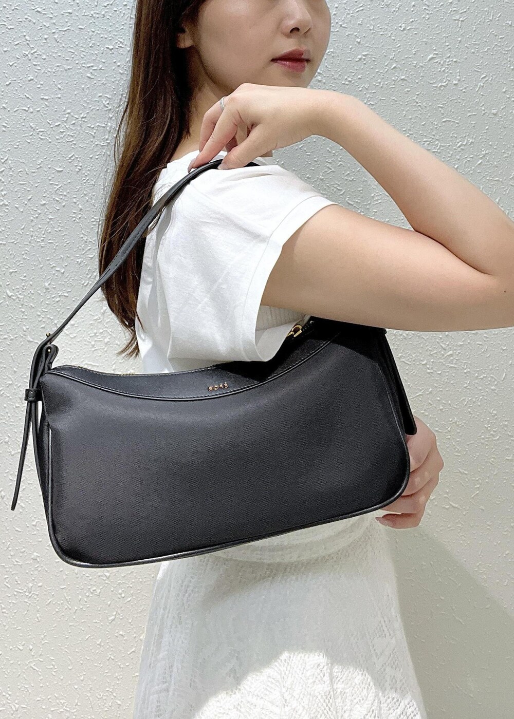 シルバー系のサンダル、ホワイト系のスカート、ブラック系のハンドバッグを着用したレディースの夏コーディネートの8枚目の写真
