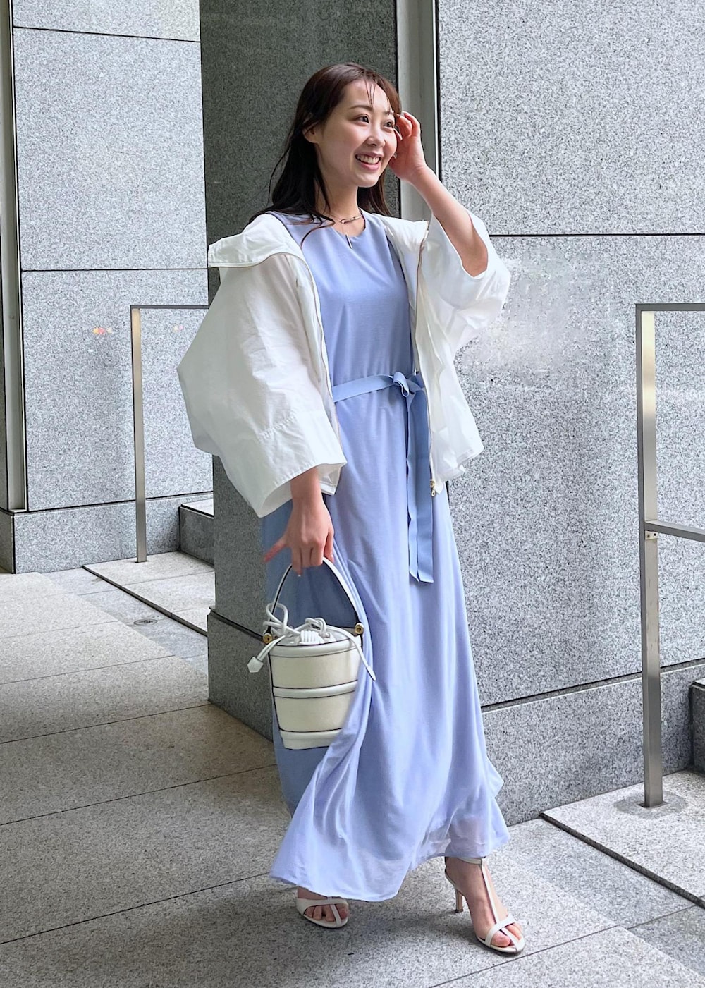 ホワイト系のハンドバッグ、ホワイト系のサンダル、ホワイト系のマウンテンパーカーを着用したレディースの春コーディネートの6枚目の写真