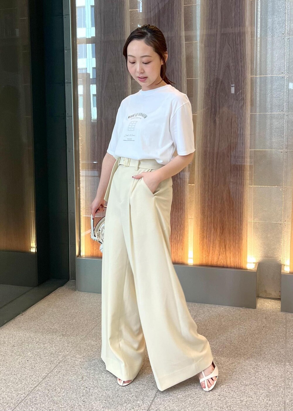 ホワイト系のハンドバッグ、ホワイト系のサンダル、ホワイト系のTシャツ/カットソーを着用したレディースの春コーディネートの5枚目の写真