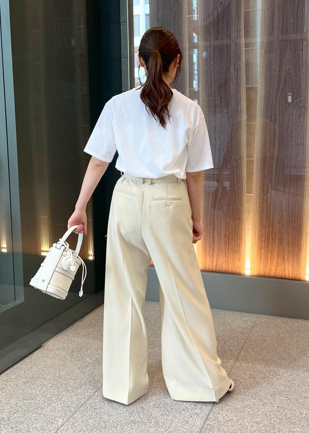 ホワイト系のハンドバッグ、ホワイト系のサンダル、ホワイト系のTシャツ/カットソーを着用したレディースの春コーディネートの4枚目の写真